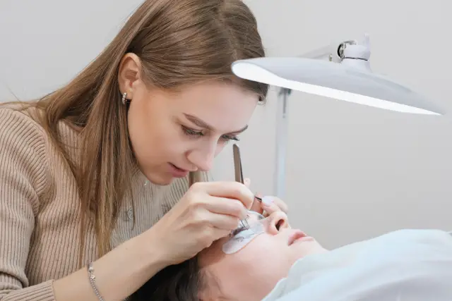 applying false eyelashes to a client