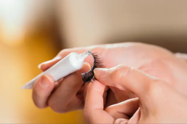 applying glue on false eyelash